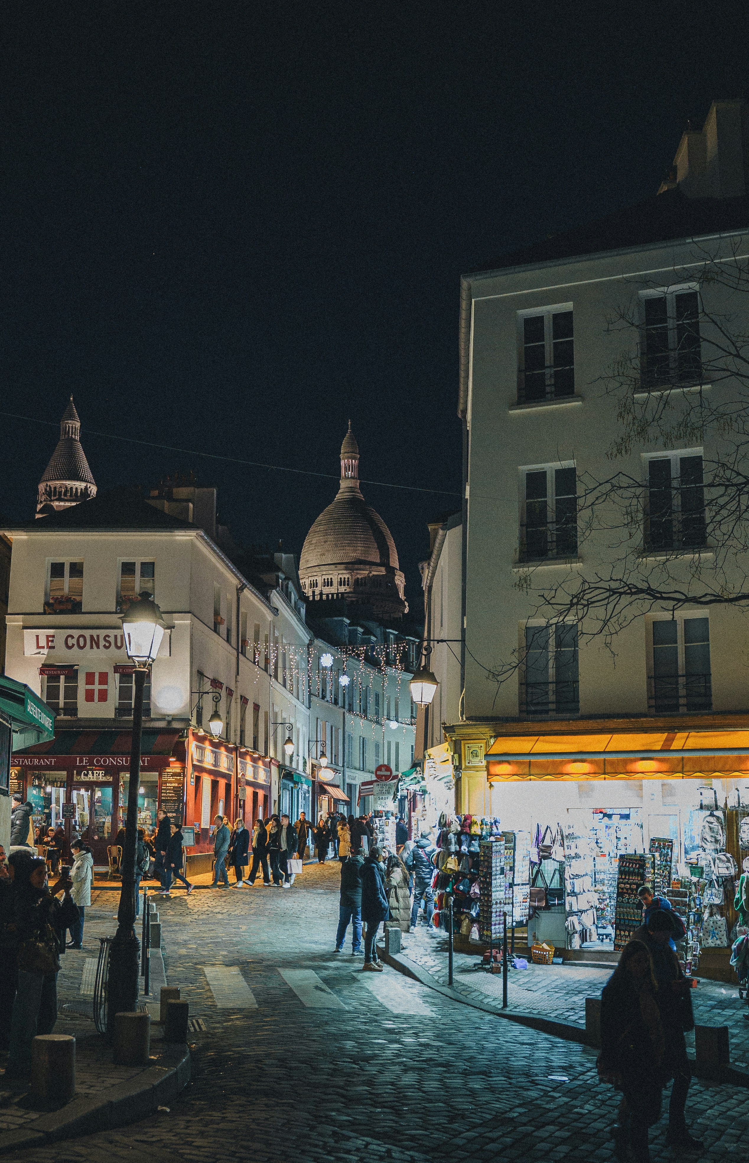 Un groupe de personnes marchant dans une rue à côté de grands immeubles