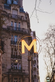 A tall building with a neon m on it's side