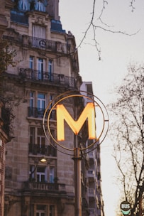 A tall building with a neon m on it's side