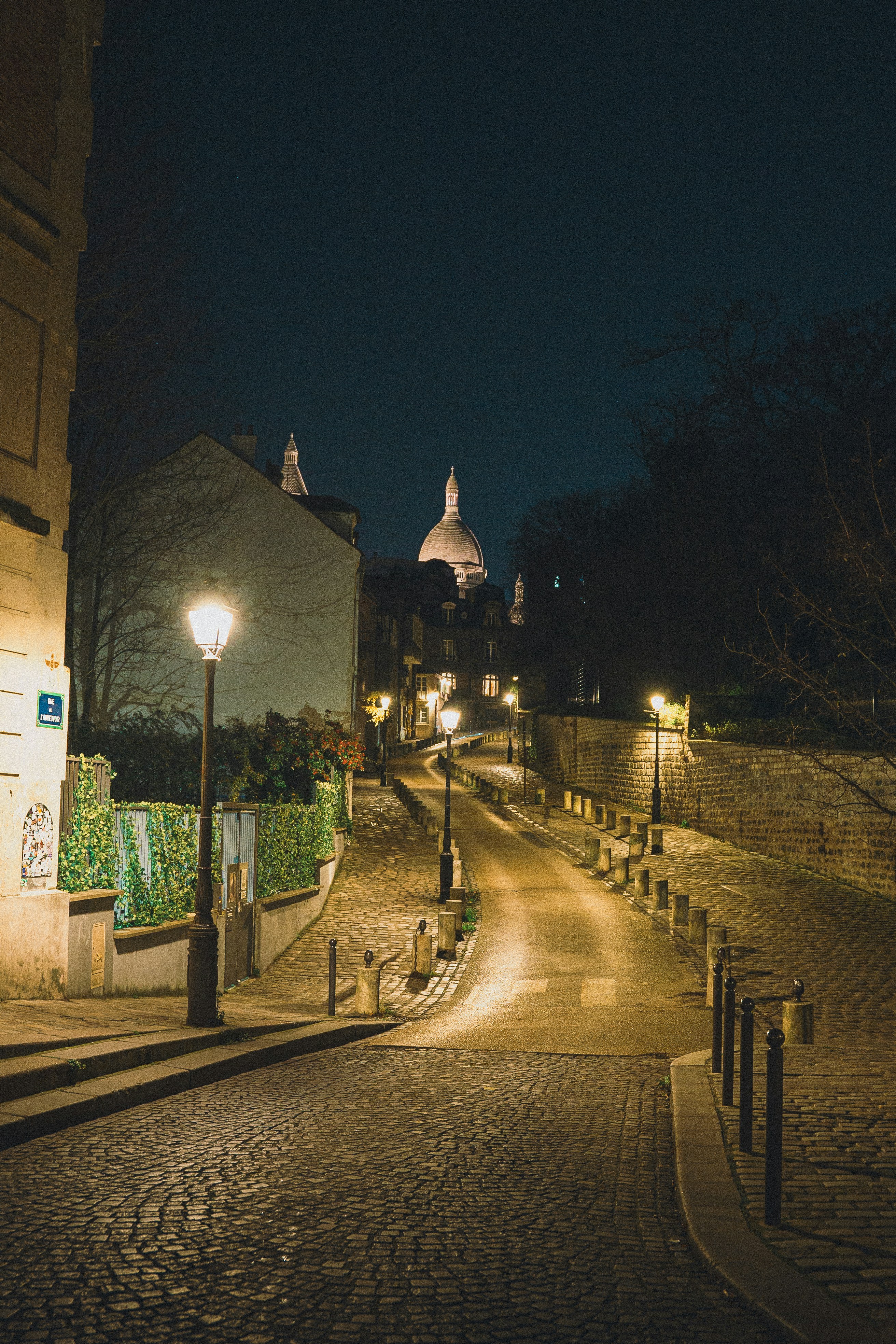 Une rue pavée la nuit avec des lumières allumées