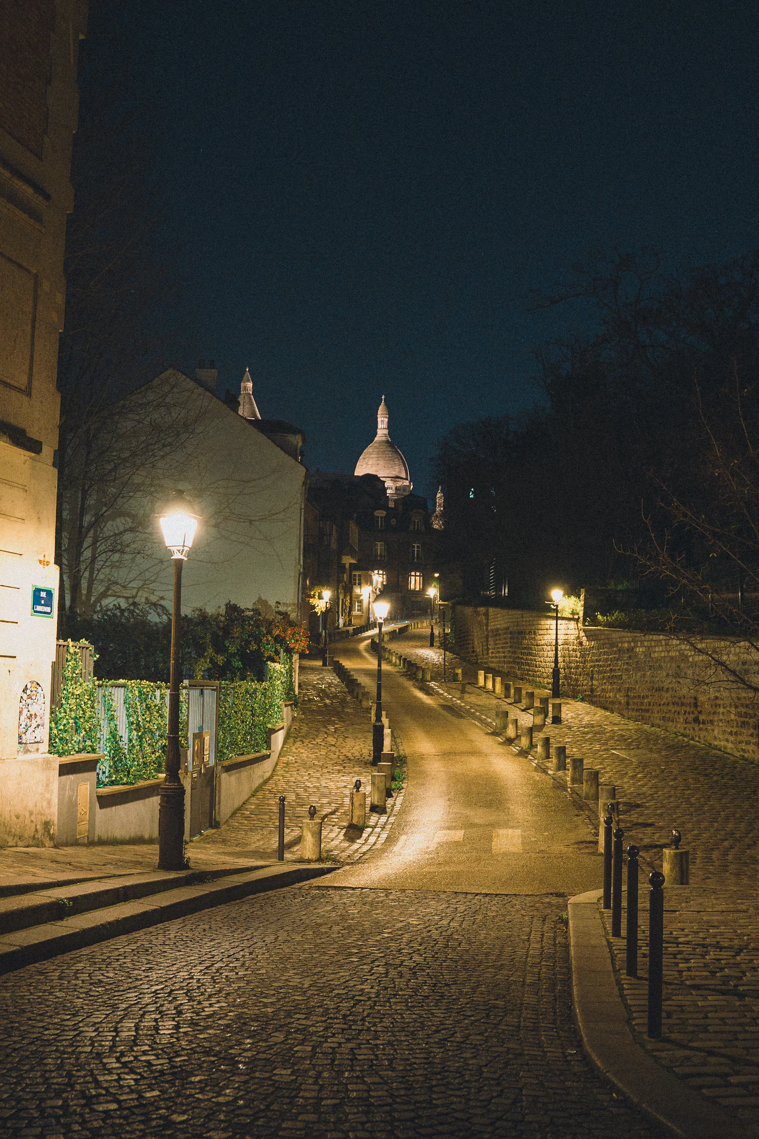 A lamplit cobbled street in Montmartre at night