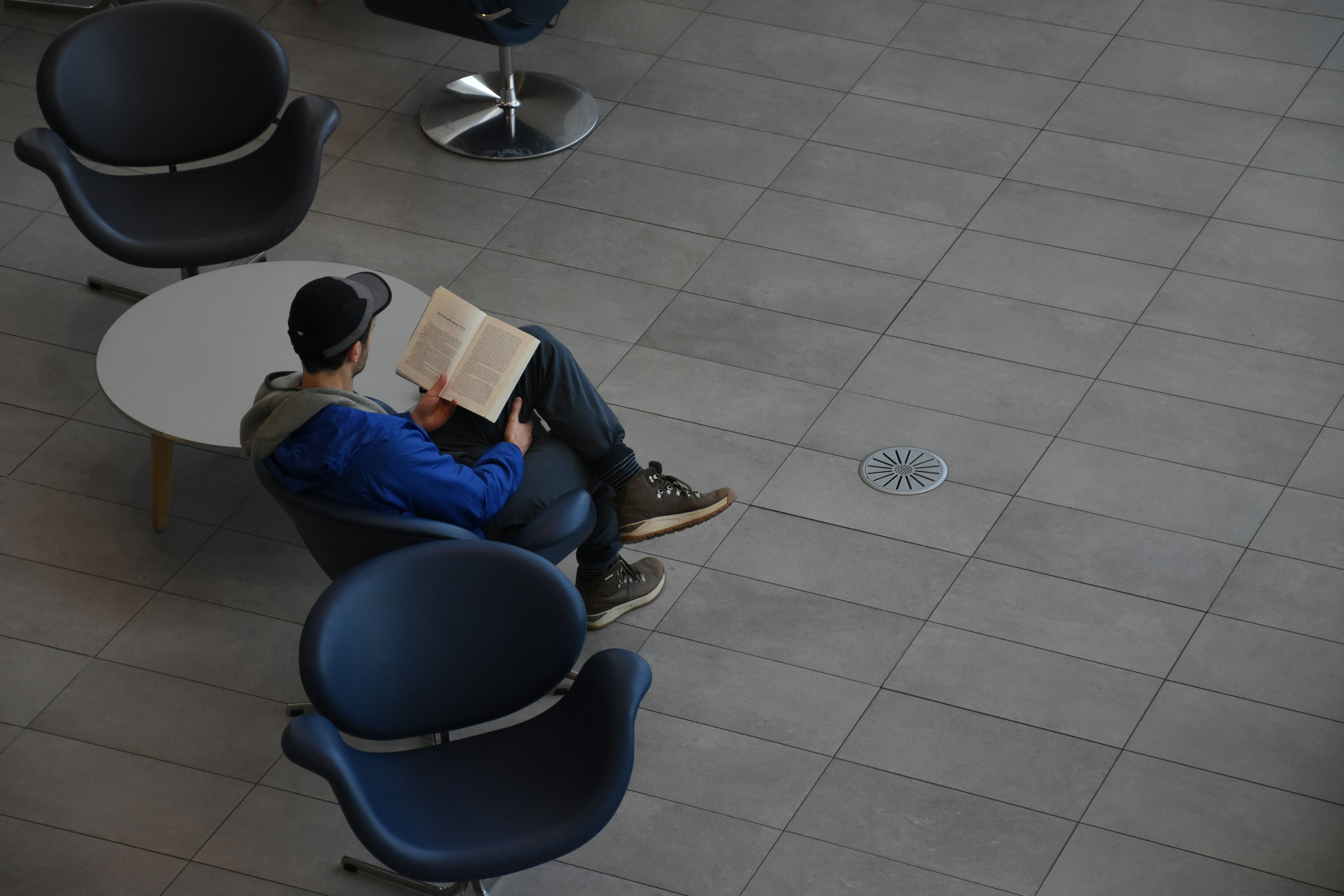 Man sitting in chair reading book
