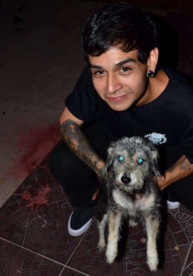 A man holding a dog on a tiled floor