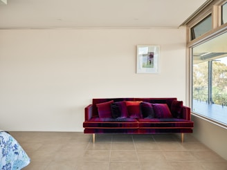 A living room with a red couch next to a window