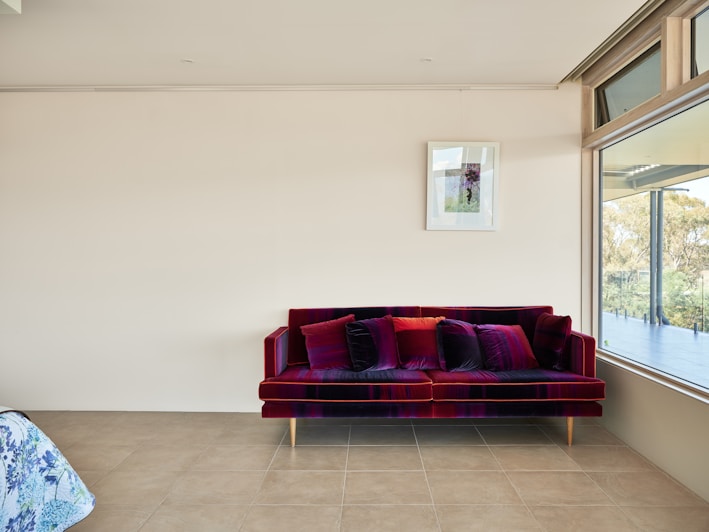 A living room with a red couch next to a window