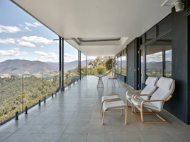A balcony with chairs and a view of the mountains
