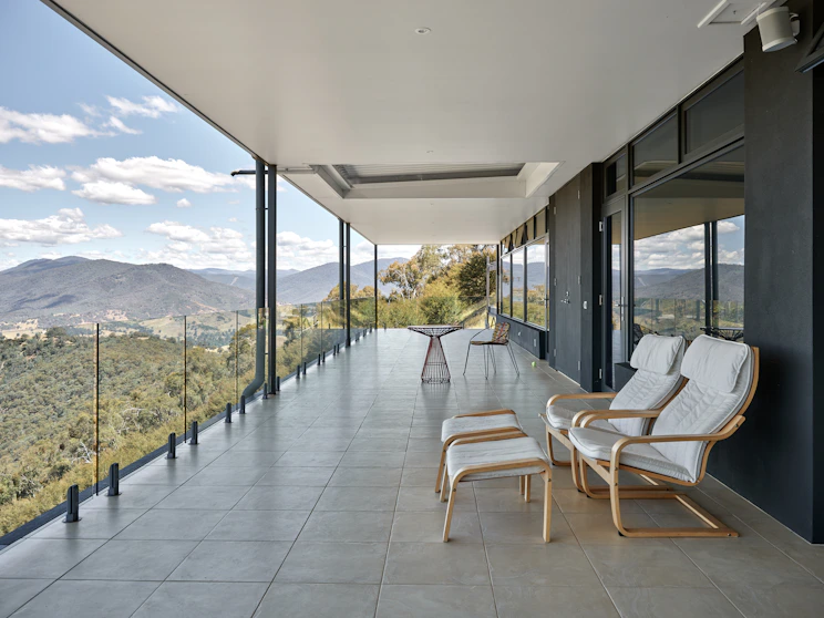 A balcony with chairs and a view of the mountains