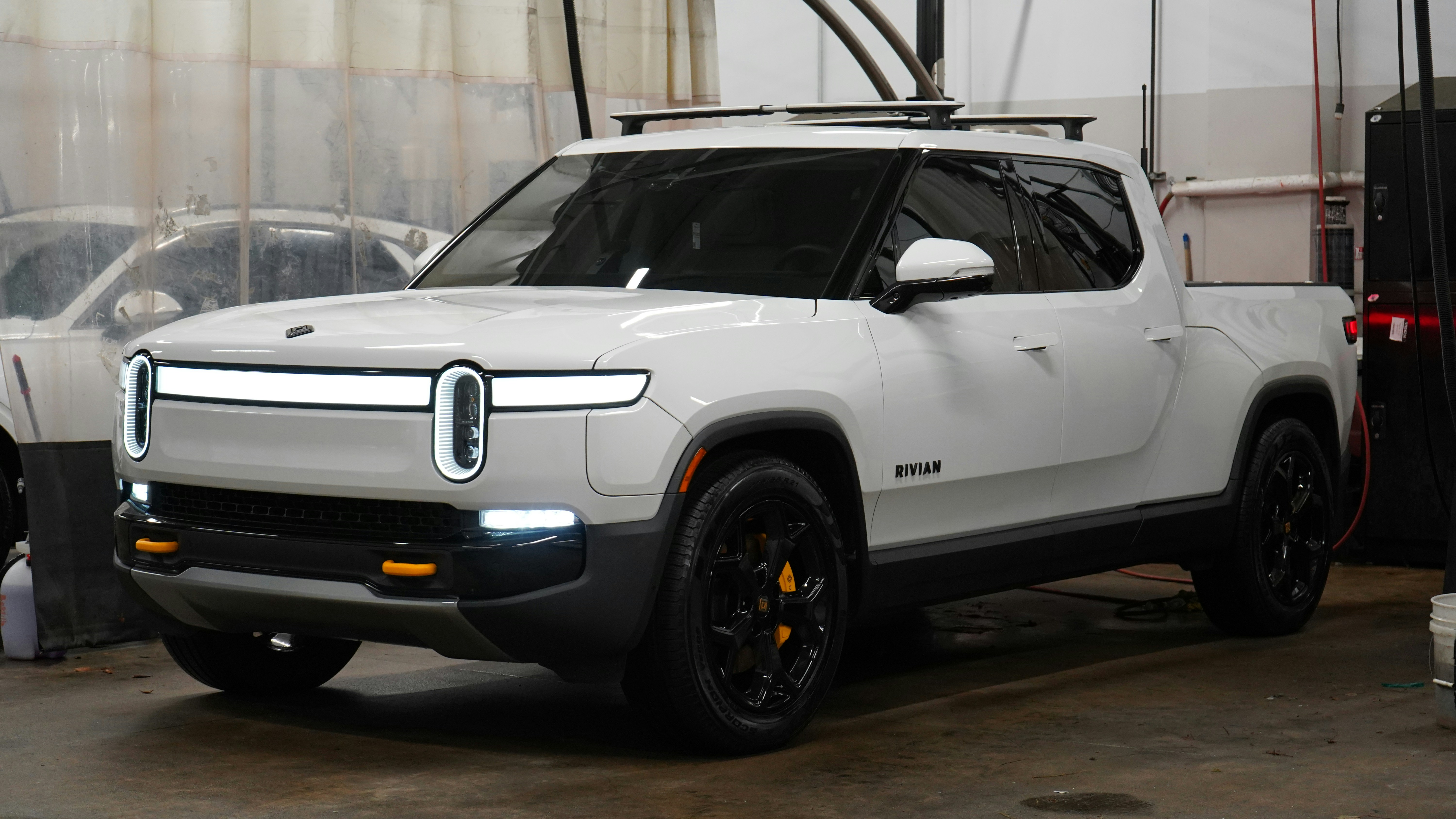 A white jeep is parked in a garage