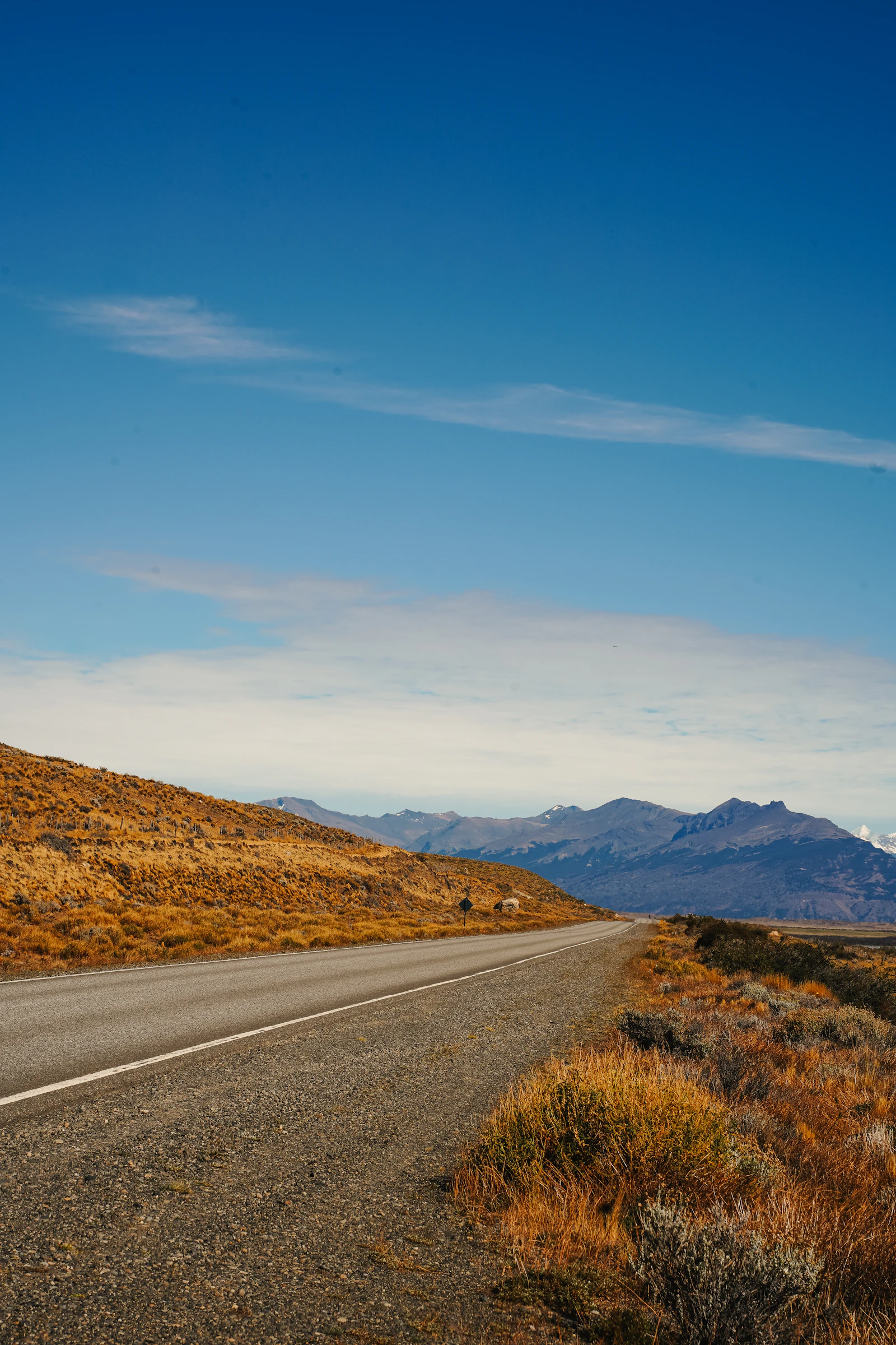 An empty paved road crossing exposed country near El Calafate