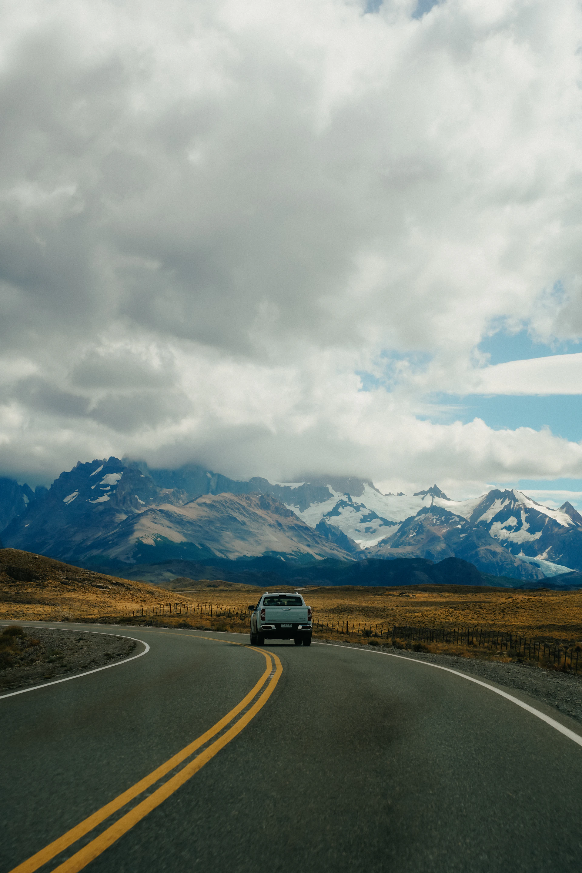 A car driving down a road with mountains in the background