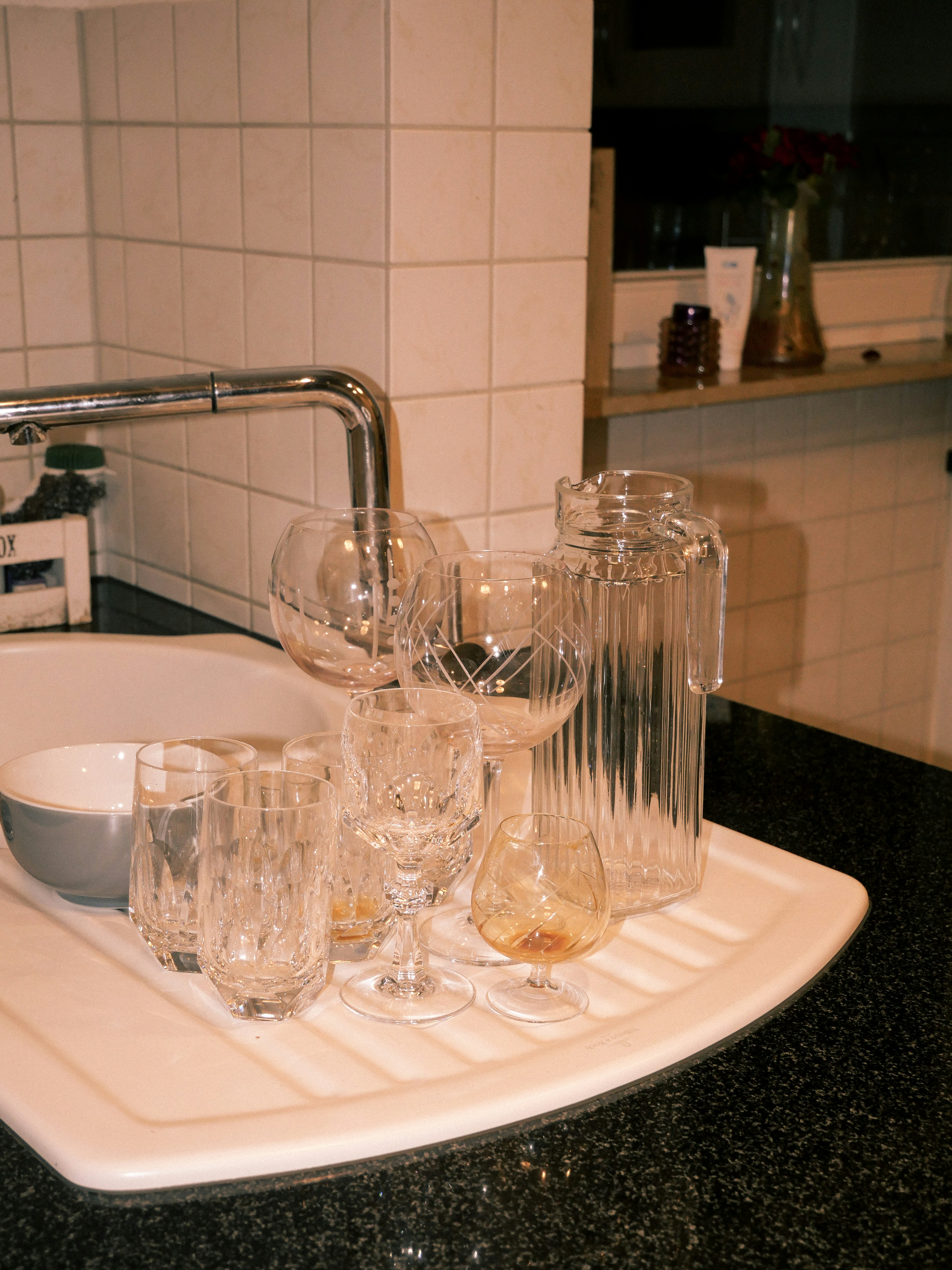 A sink with glasses and a bowl on it
