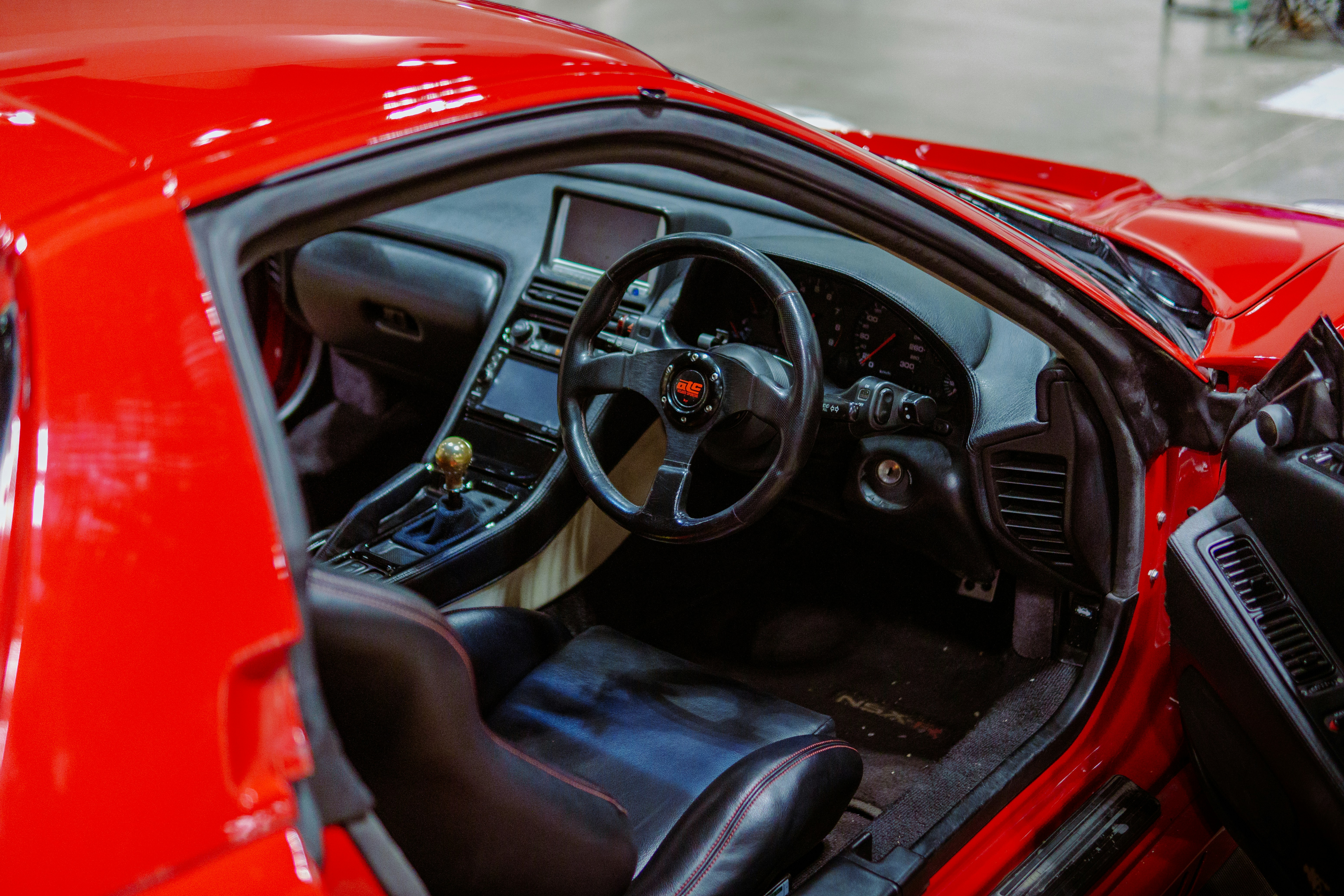 The interior of a red sports car in a showroom