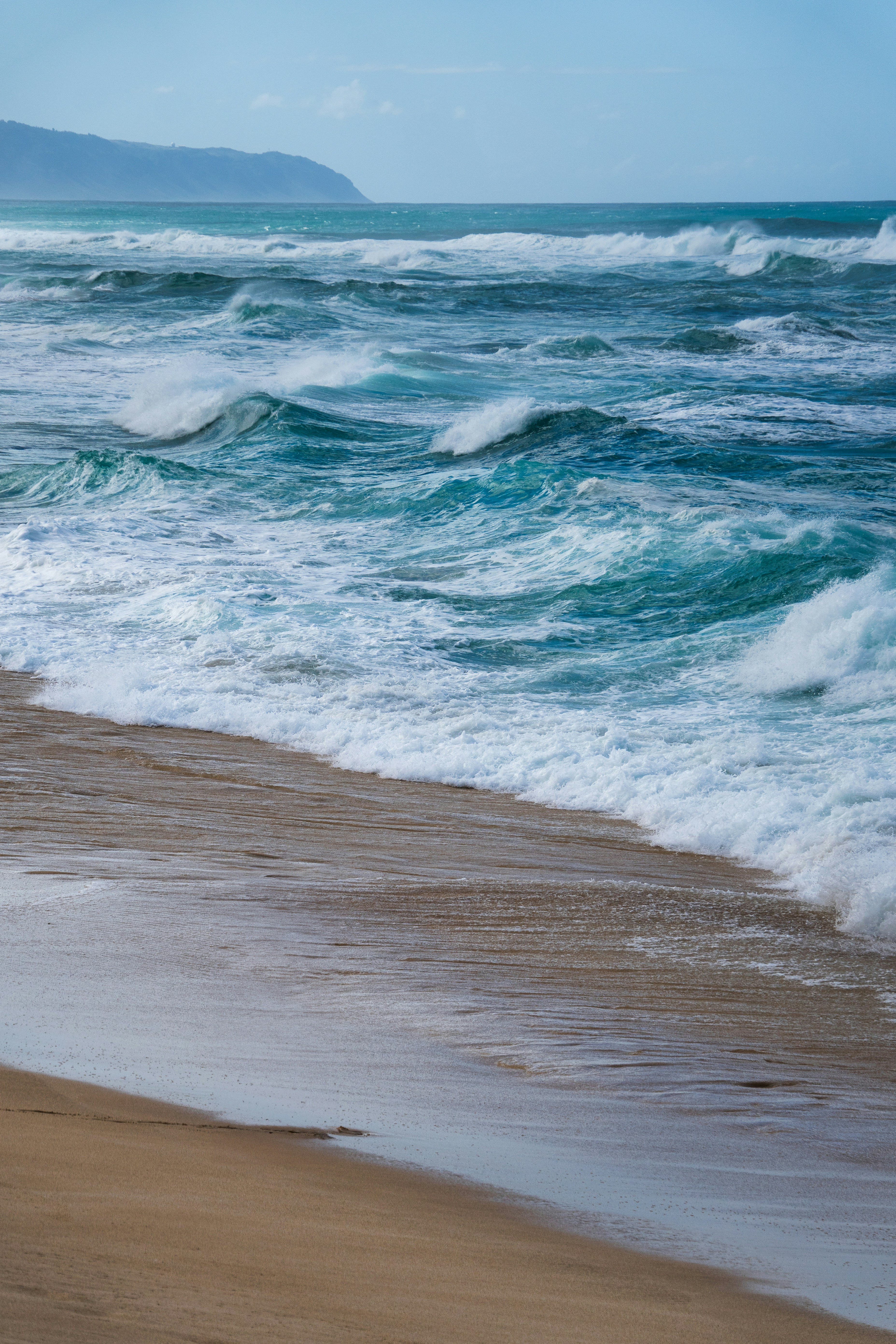 Une personne marchant sur la plage avec une planche de surf