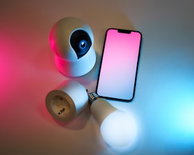 A smart phone sitting on top of a table next to a flashlight