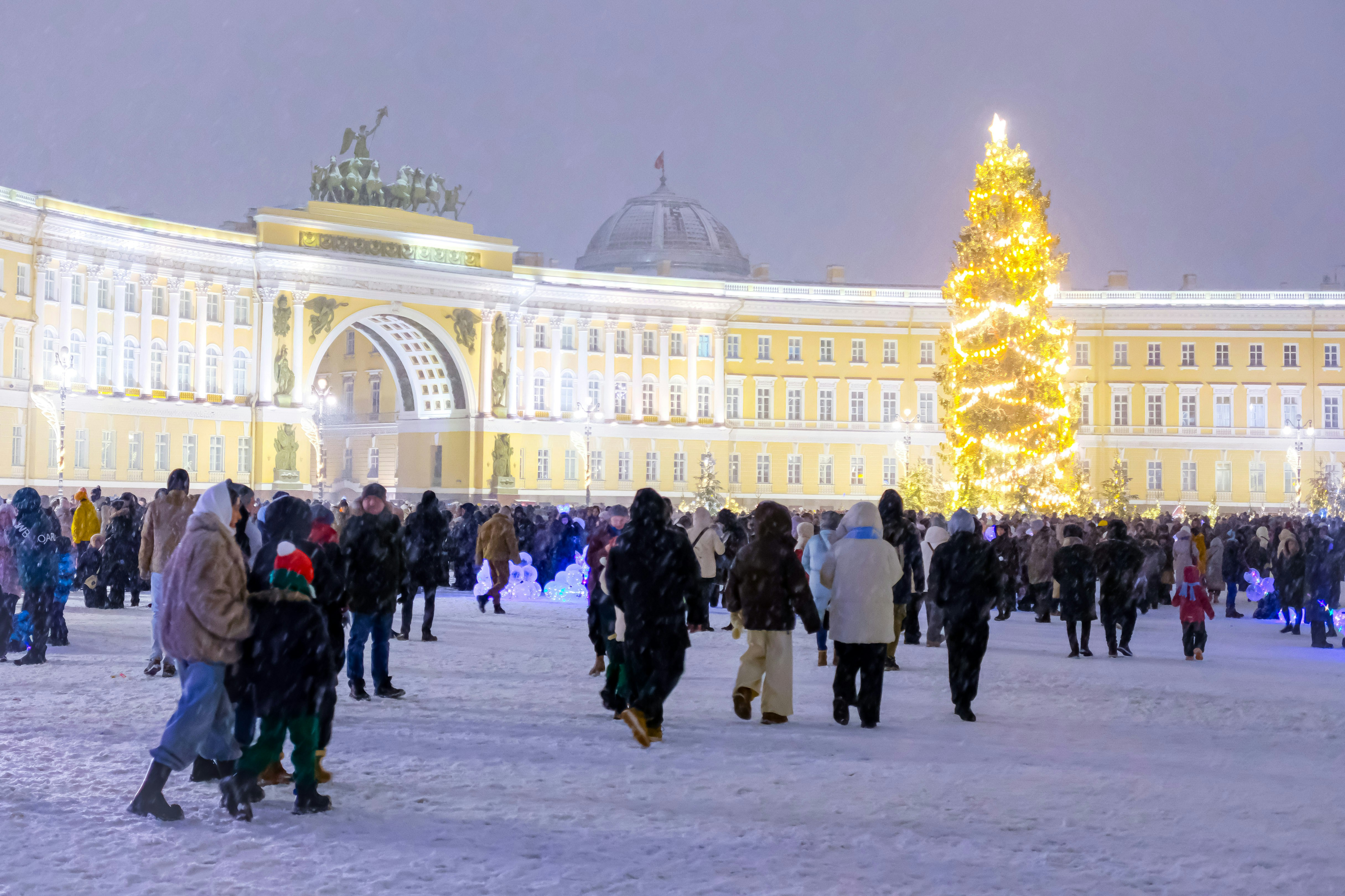 A large group of people standing around a christmas tree