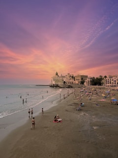 A group of people standing on top of a sandy beach