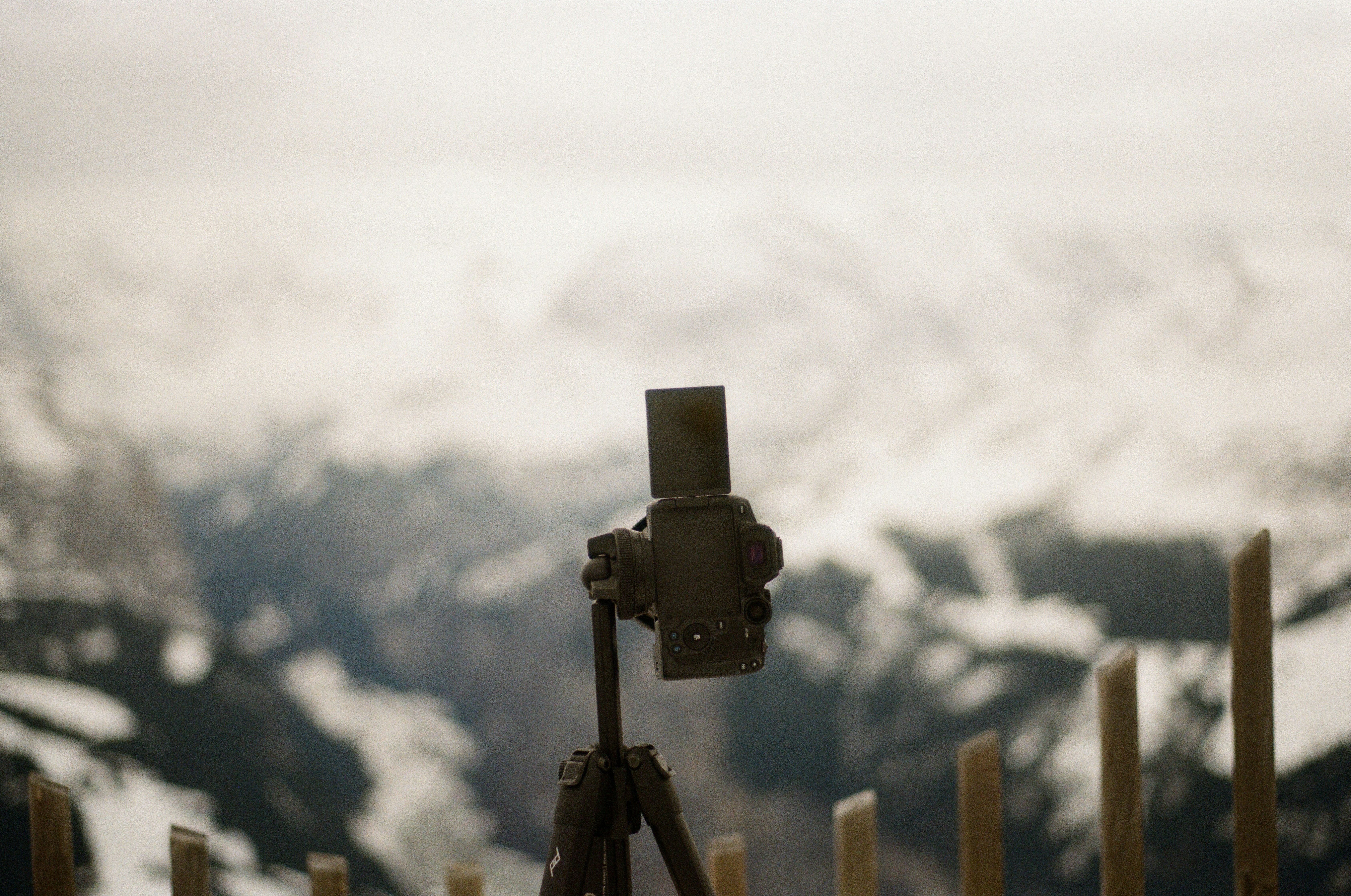Un trépied posé sur une clôture en bois
