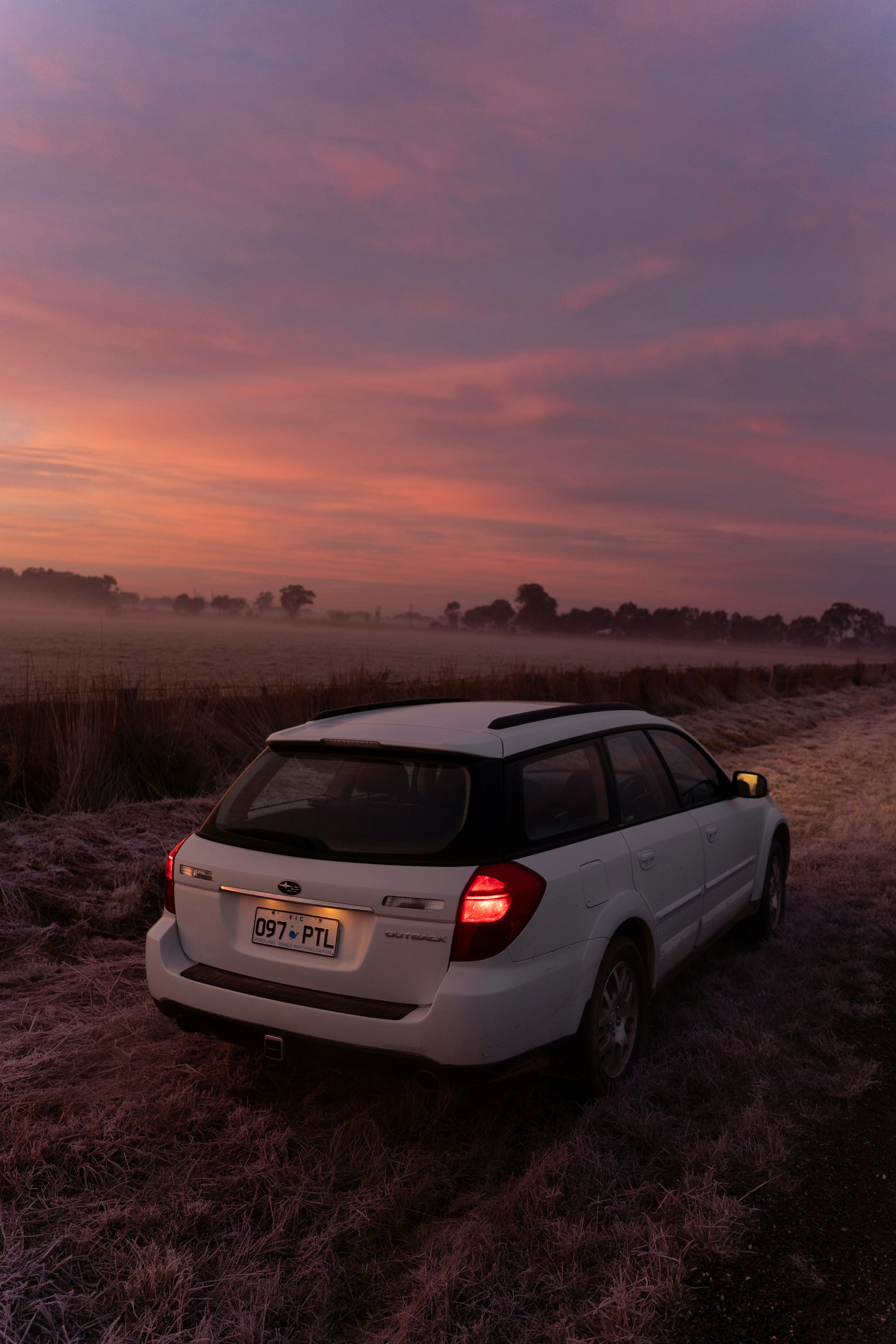 A white car parked on a dirt road
