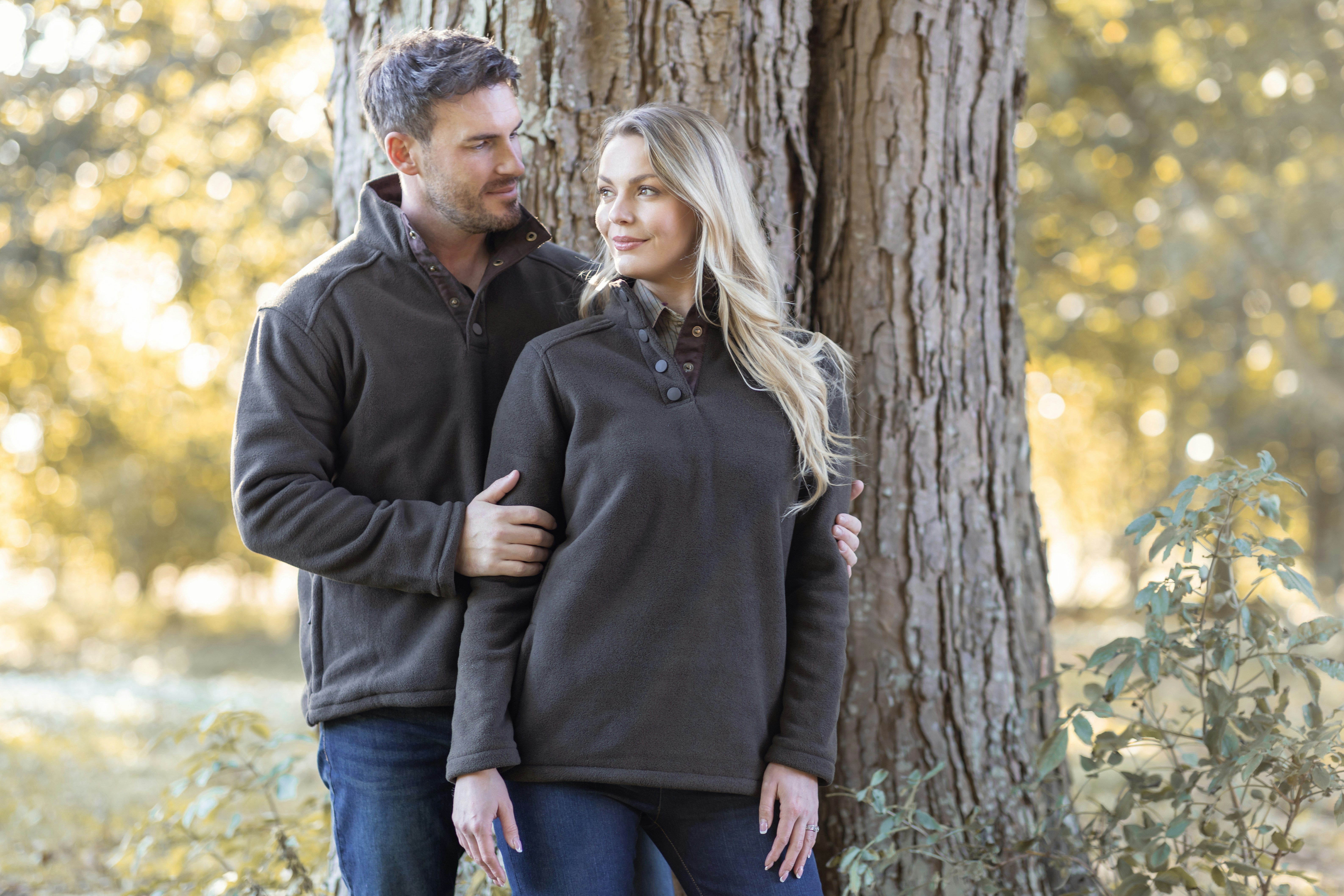 A man and woman standing in front of a tree
