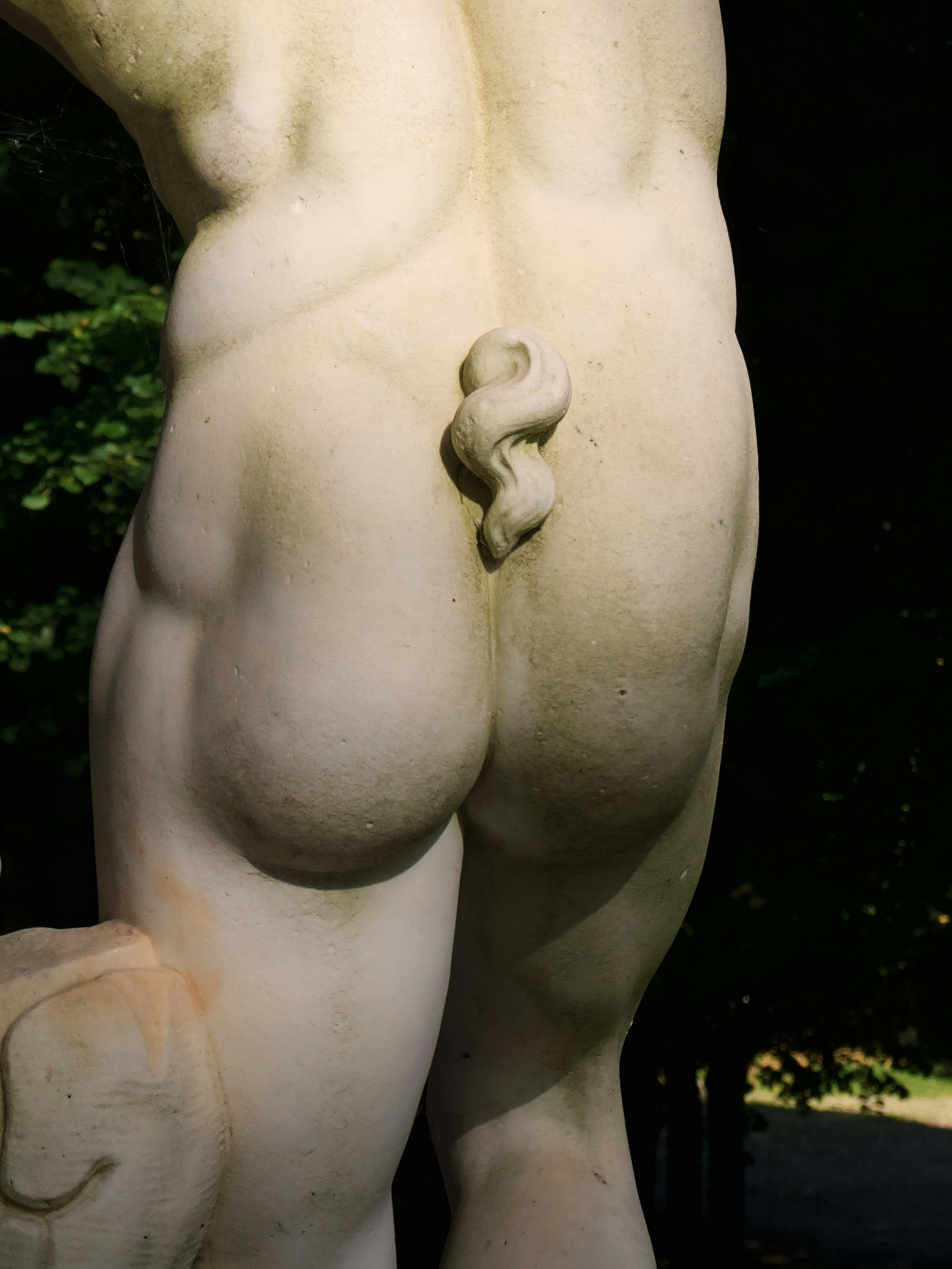 Uma estátua de um homem nu segurando uma pedra