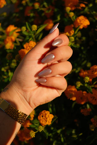 A woman's hand with a manicure holding a flower