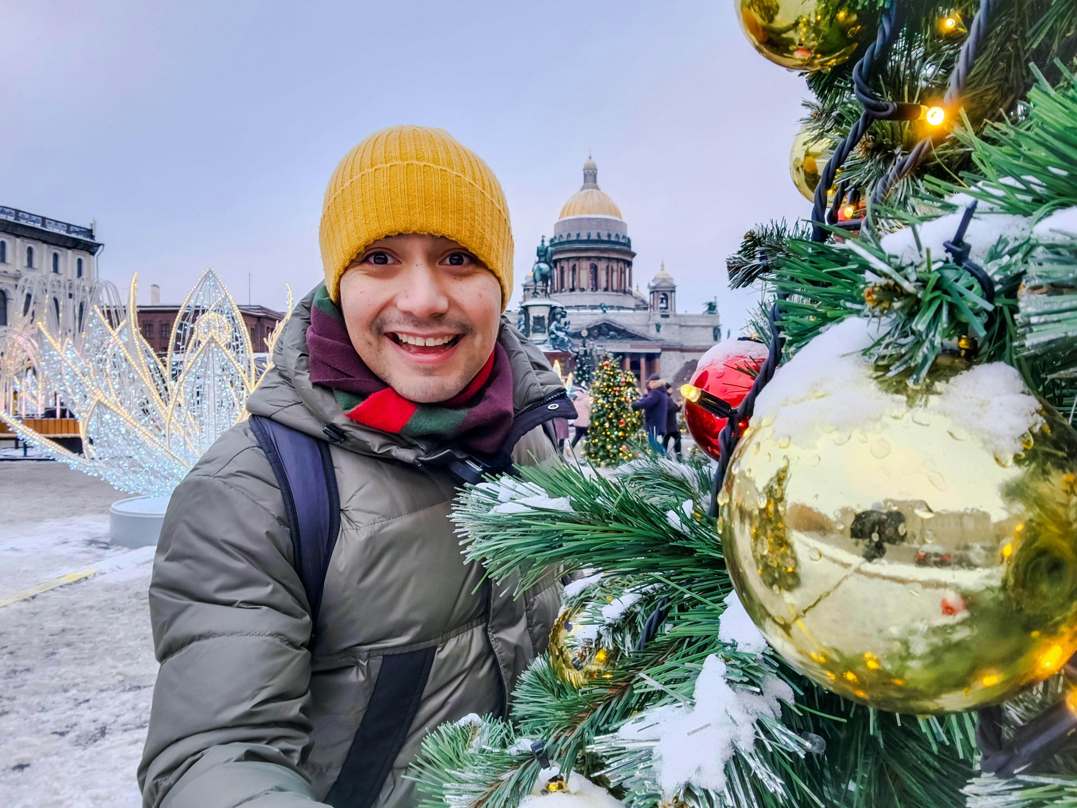 A man standing next to a christmas tree