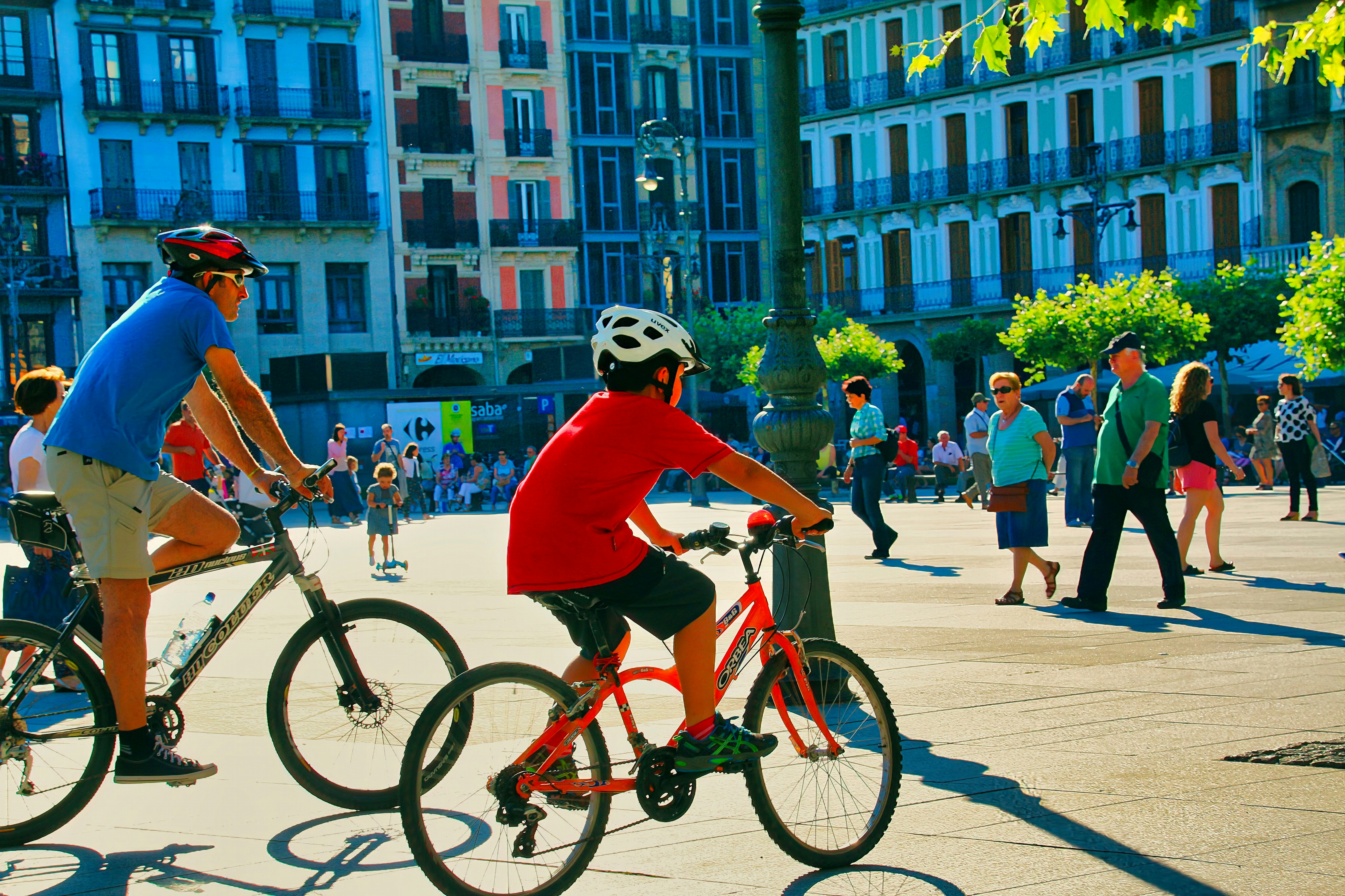 A couple of people riding bikes down a street