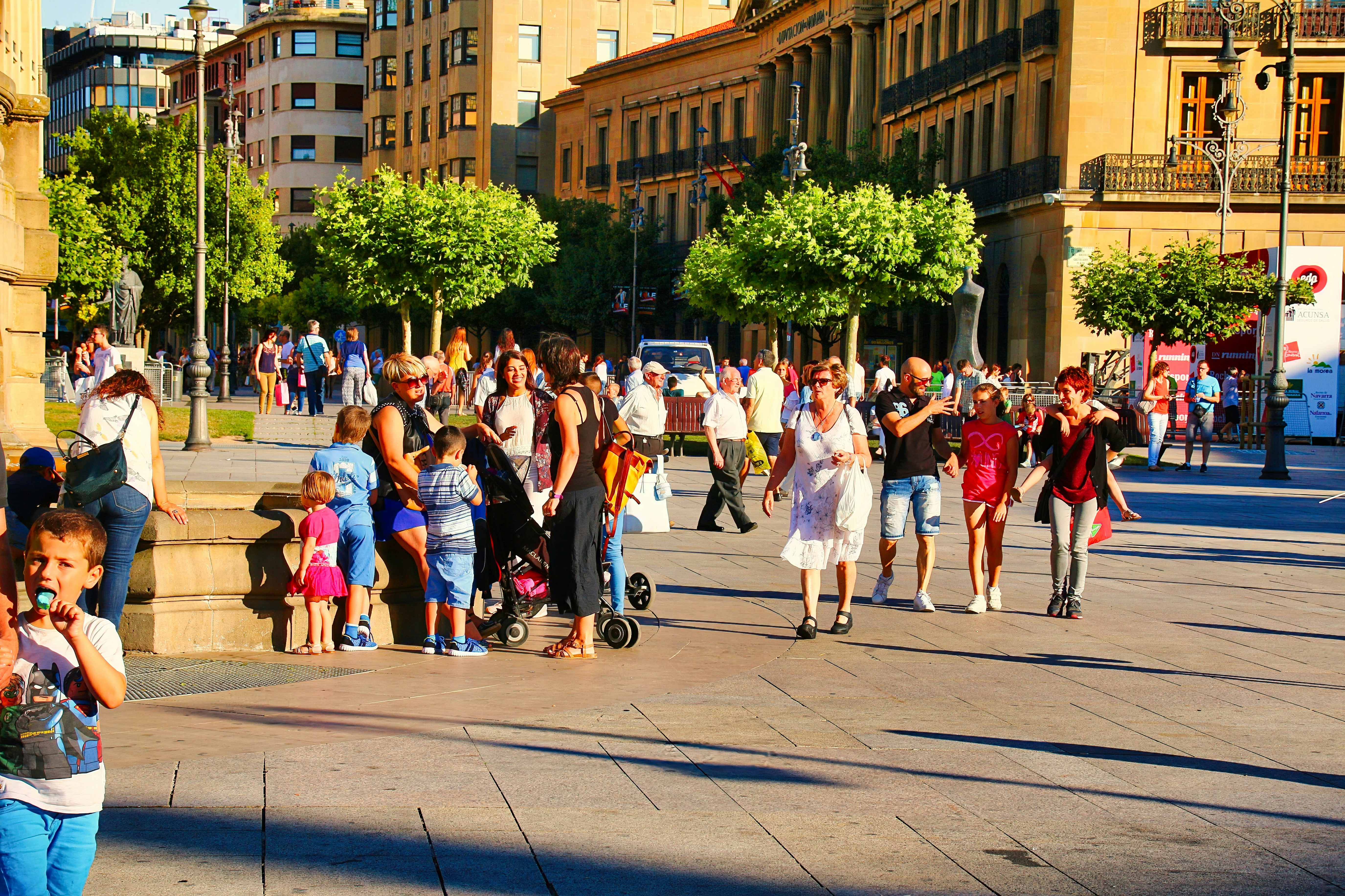 A crowd of people walking down a street next to tall buildings