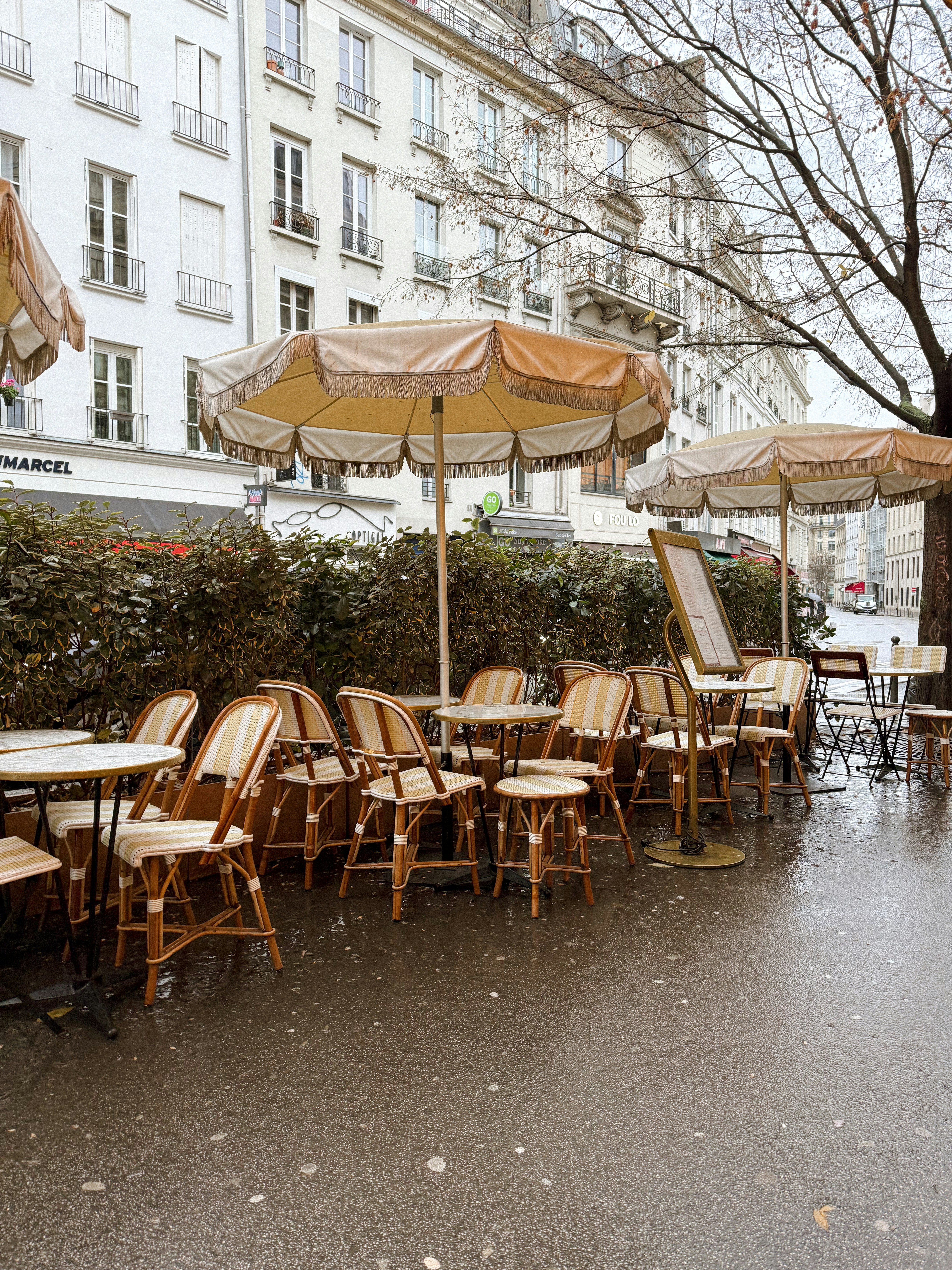 A row of tables with umbrellas on a rainy day
