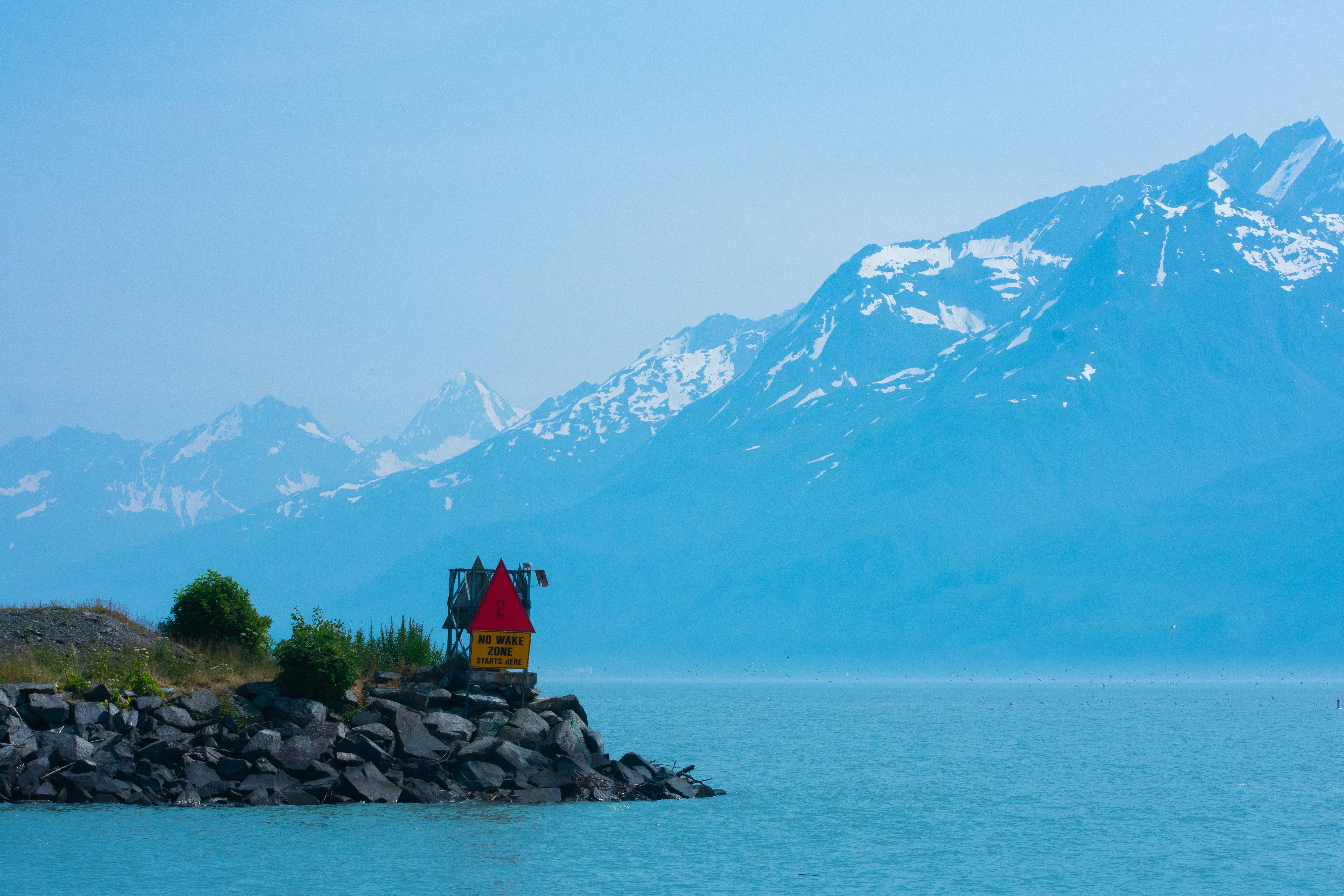 Two people standing on a small island in the middle of a lake