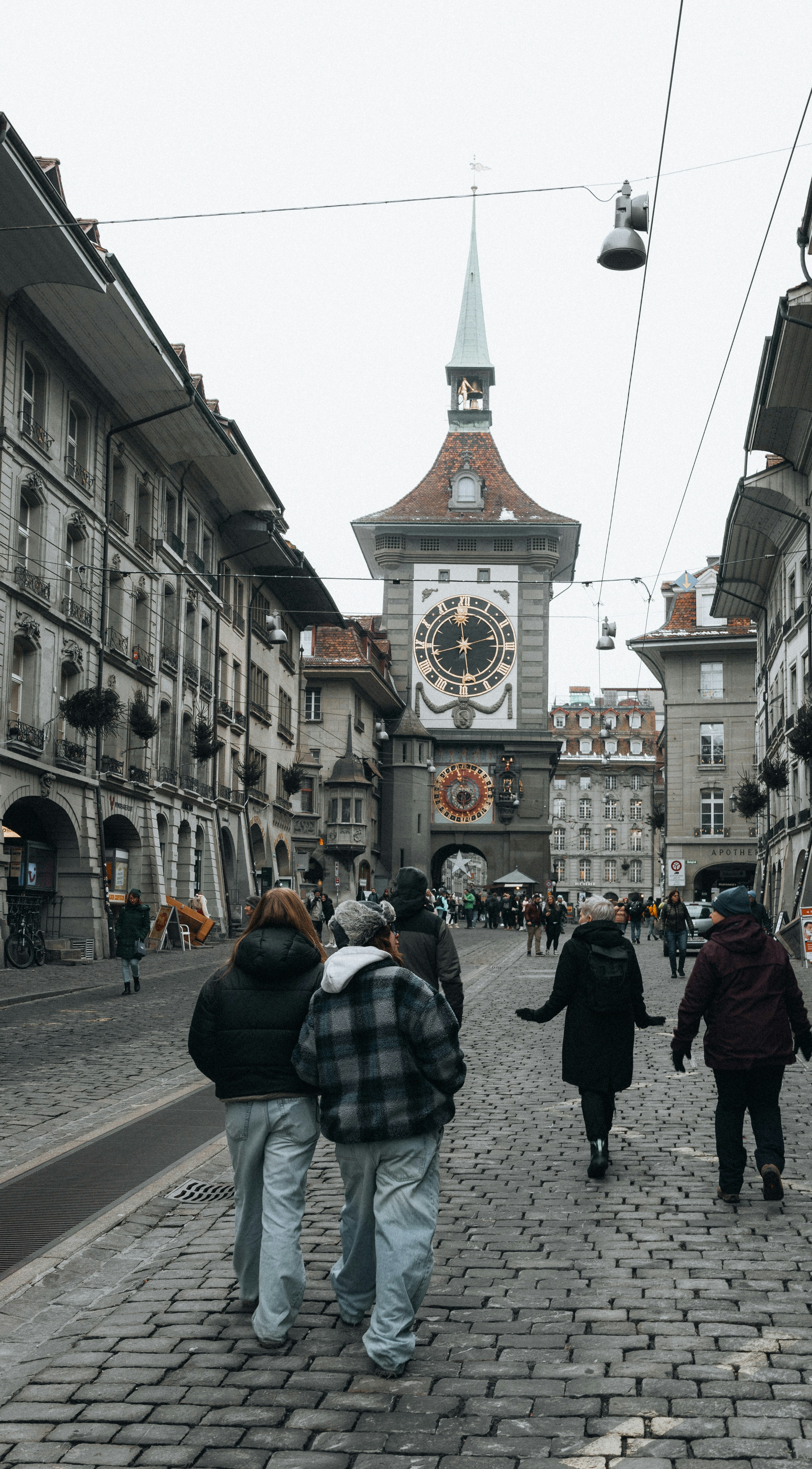 Eine Gruppe von Menschen geht eine Kopfsteinpflasterstraße entlang