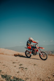 A man riding a dirt bike on top of a dirt field