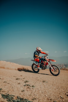 A man riding a dirt bike on top of a dirt field