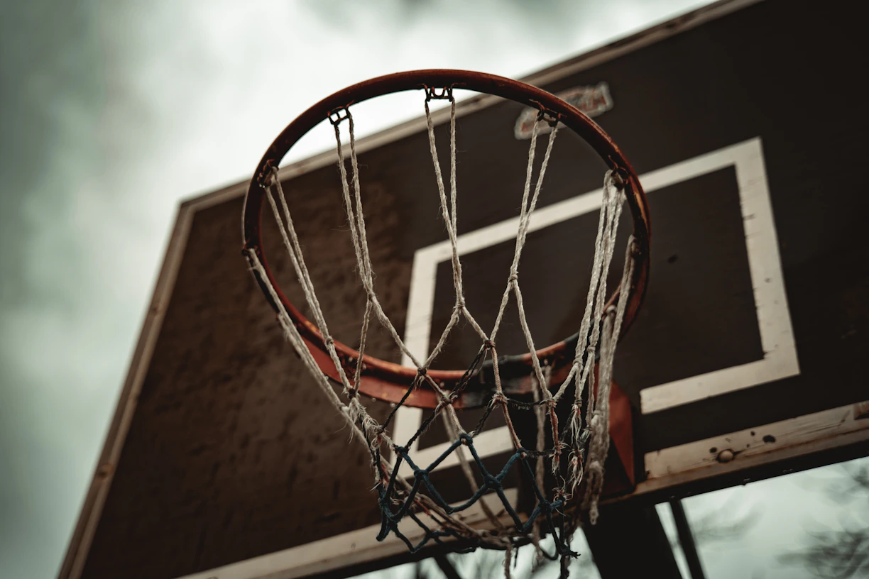A basketball hoop with a cloudy sky in the background