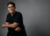 A man in a black shirt is posing for a picture
