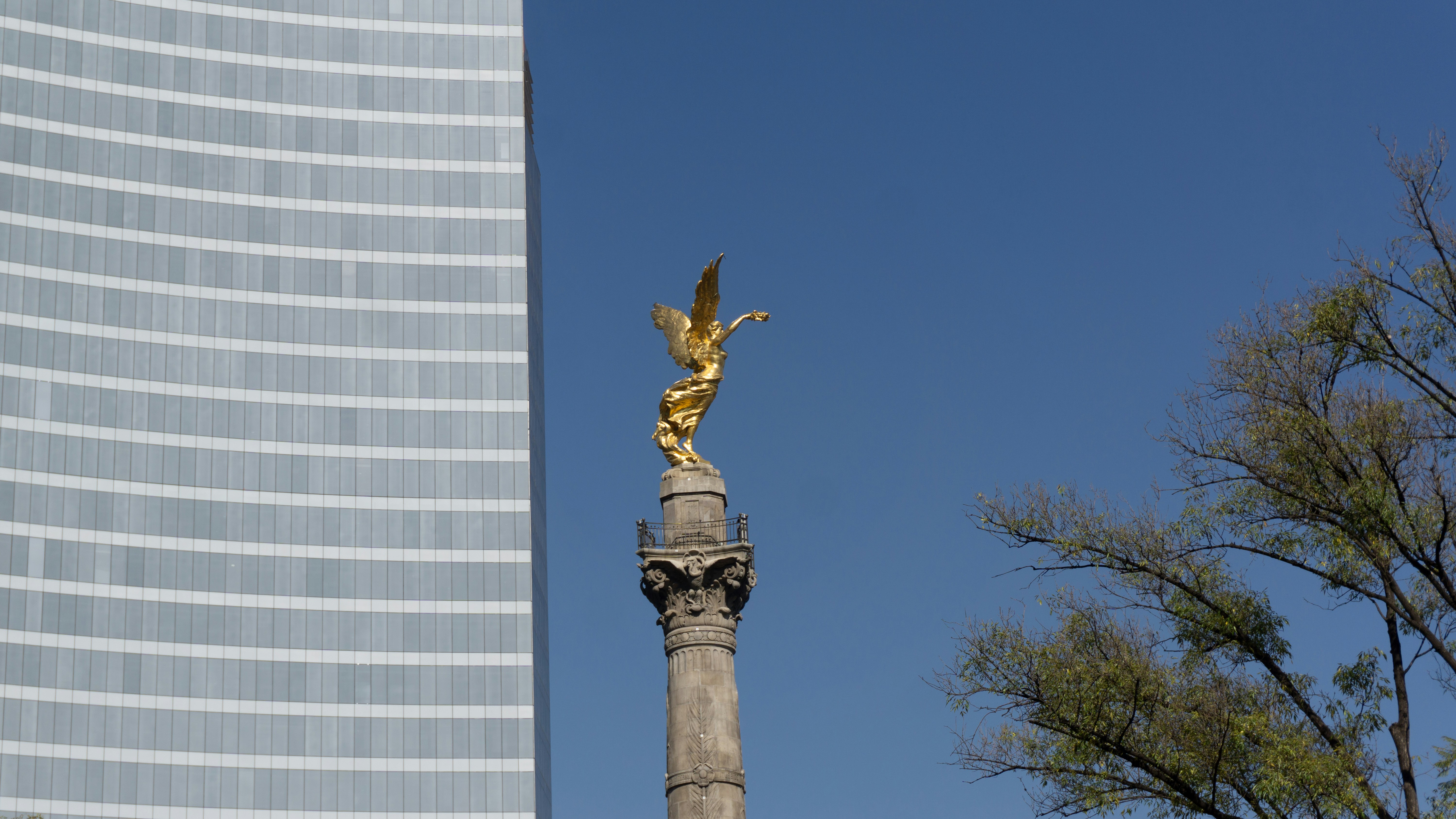 A tall building with a golden statue on top of it
