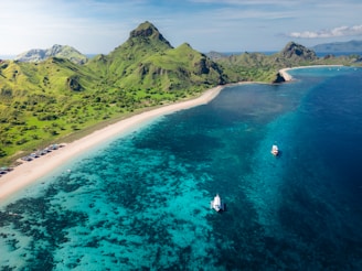 An aerial view of a tropical island with sailboats