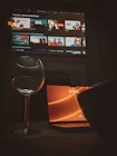 A glass of wine sitting next to a laptop computer
