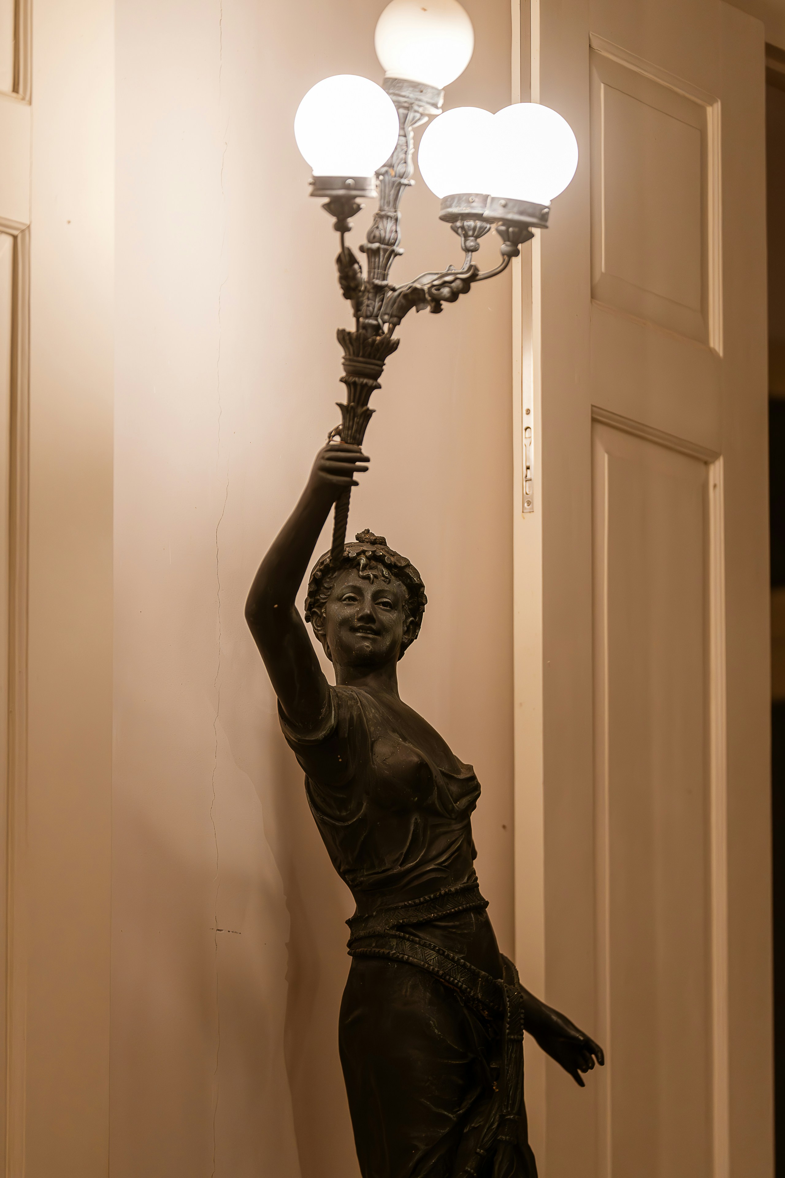 A statue of a woman holding a lamp above her head