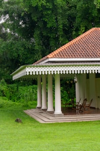 A gazebo in a grassy area with trees in the background