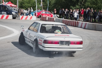 A white car driving down a race track