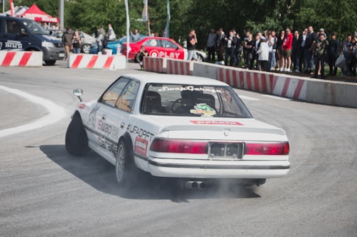 A white car driving down a race track