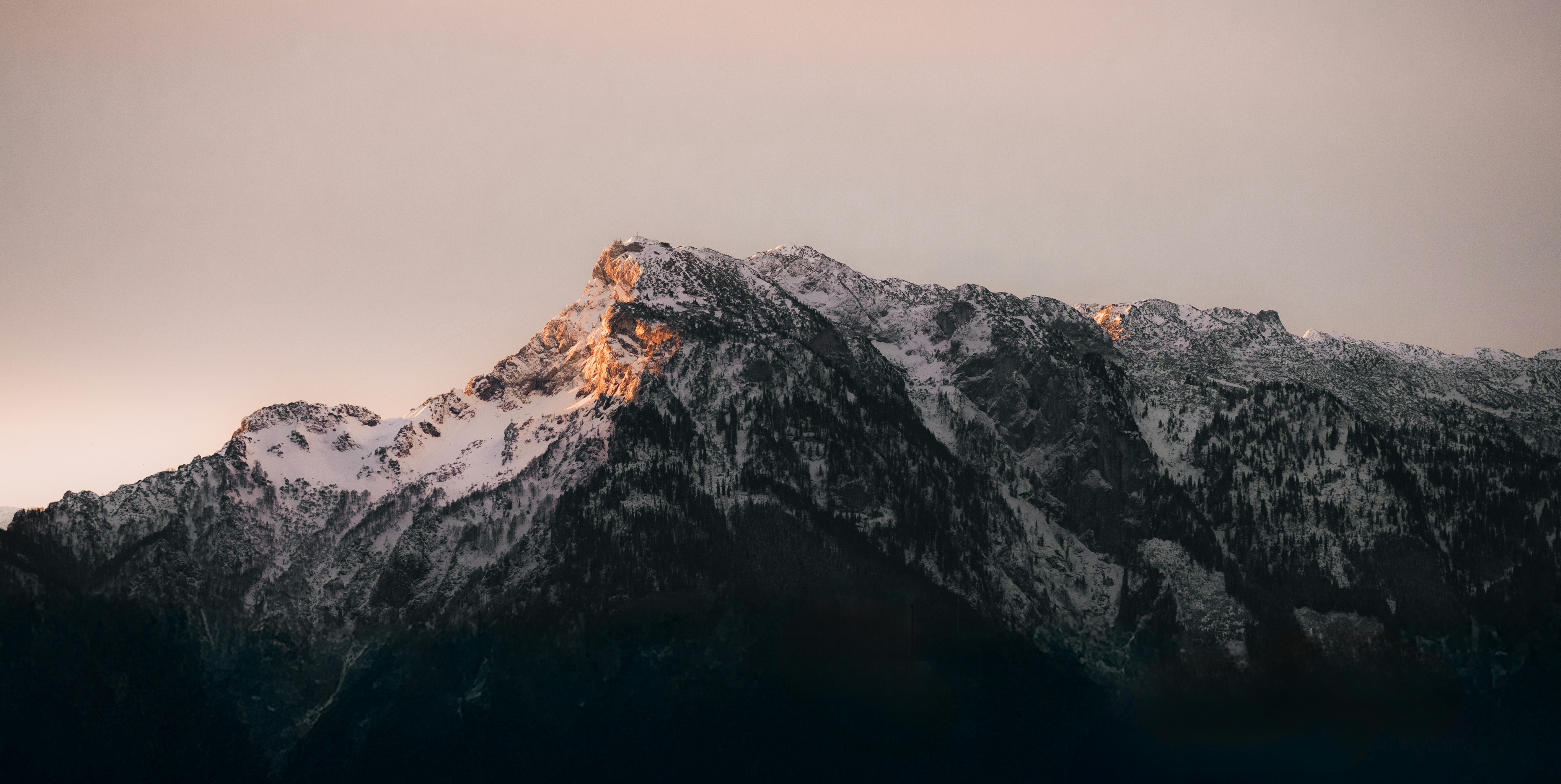 A snow covered mountain with a bird flying over it