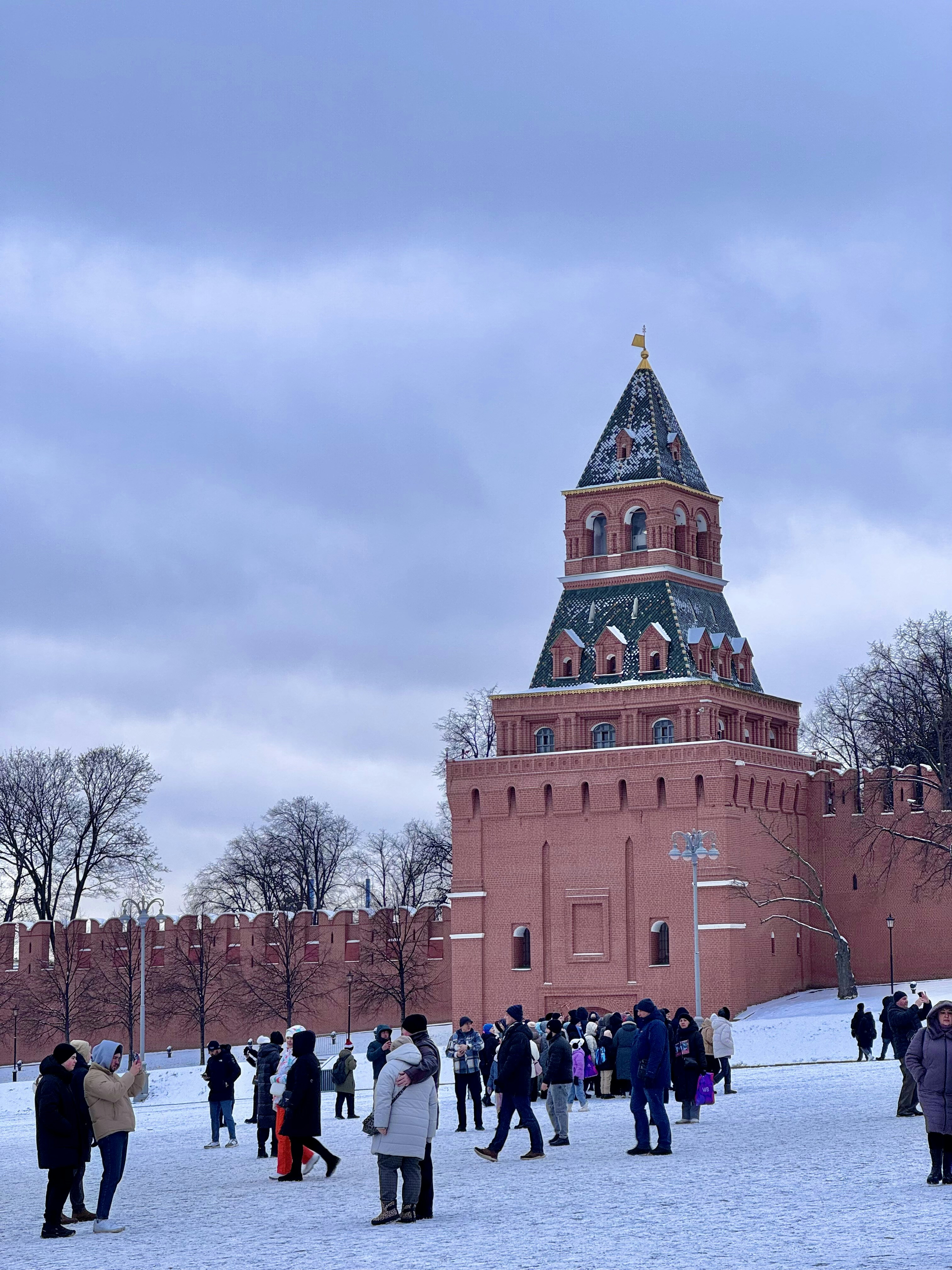 A group of people standing in the snow in front of a building