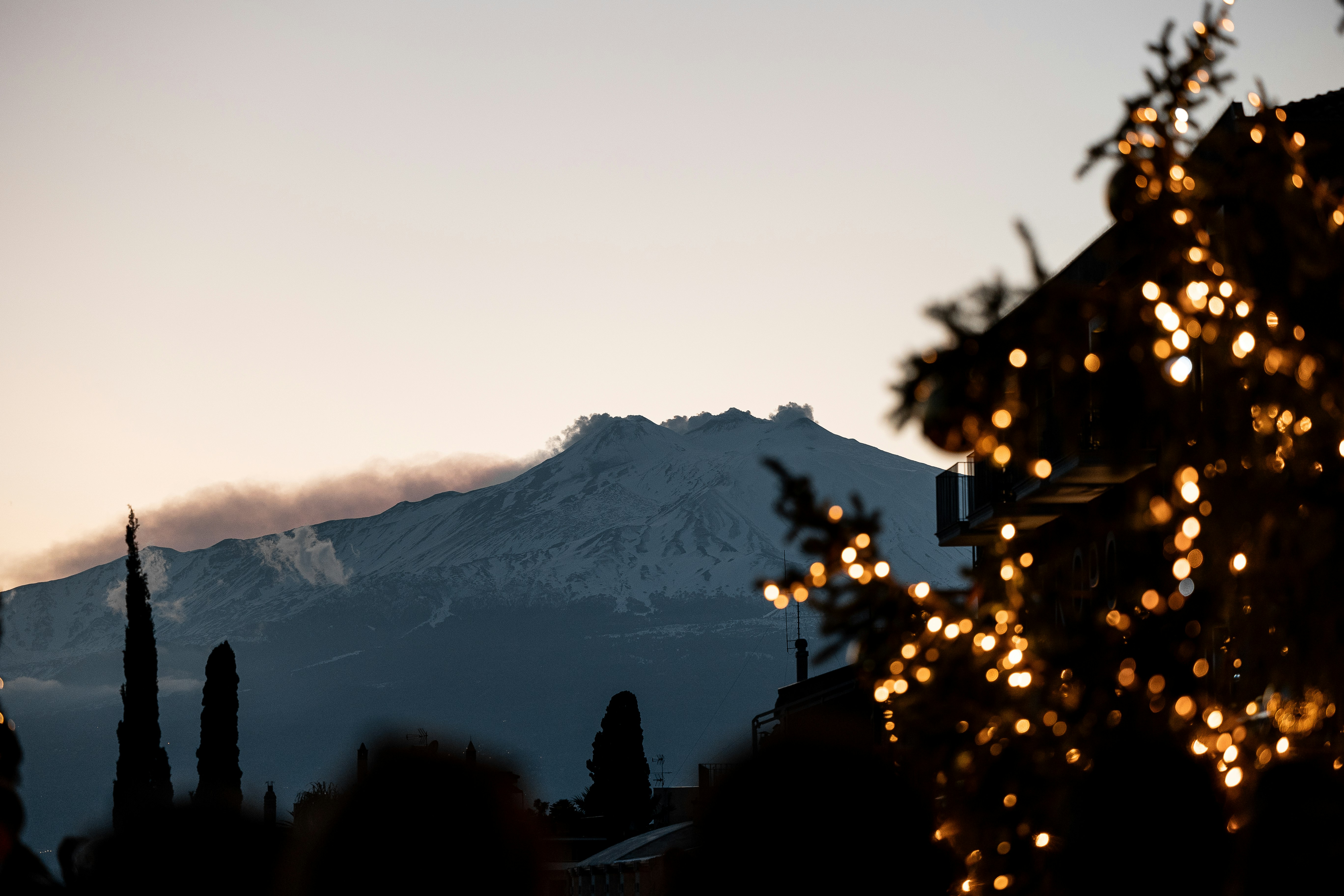 A view of a mountain with lights in the foreground