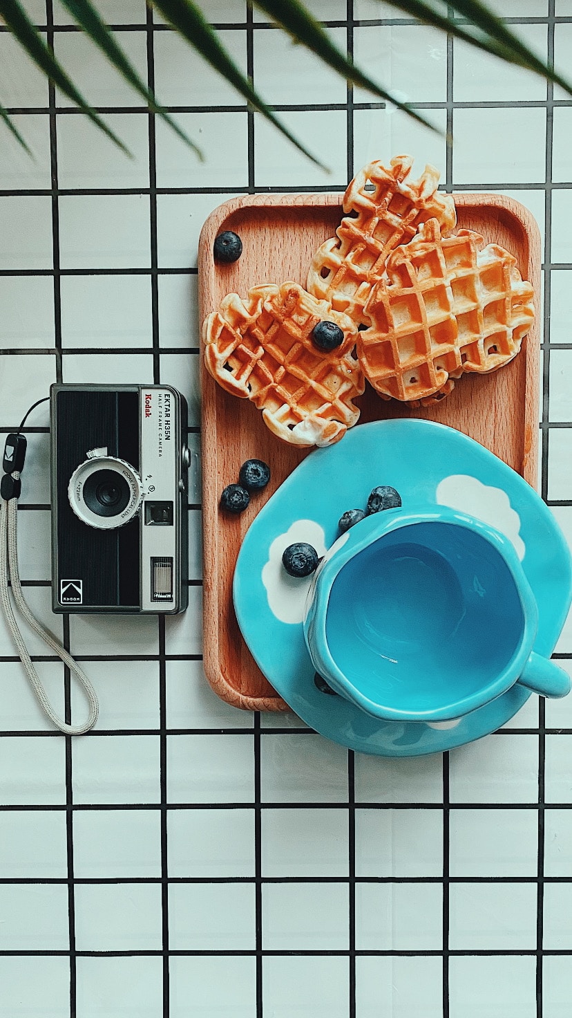 A plate of waffles and a cup of coffee
