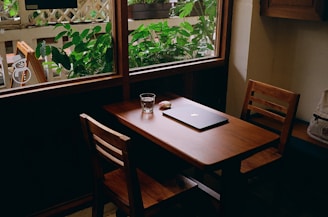 A wooden table with a laptop on top of it