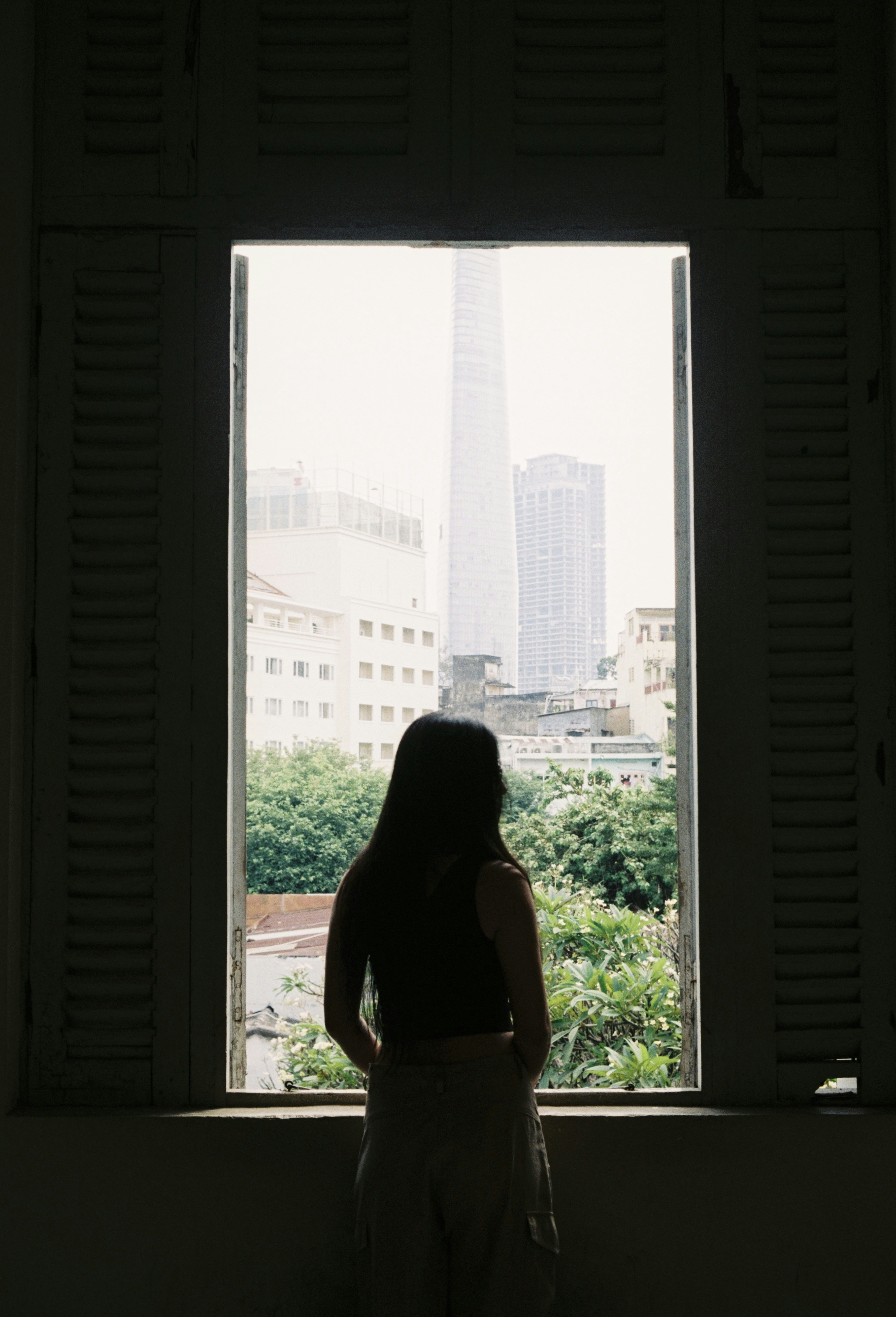A woman standing in front of a window