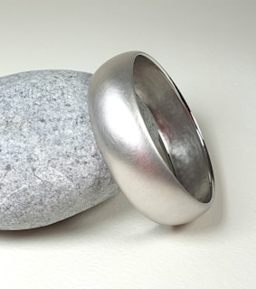 A silver ring sitting on top of a rock
