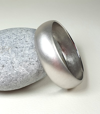 A silver ring sitting on top of a rock